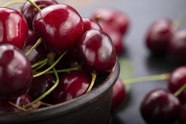 Freshly harvested cherries in a clay bowl from your home garden.