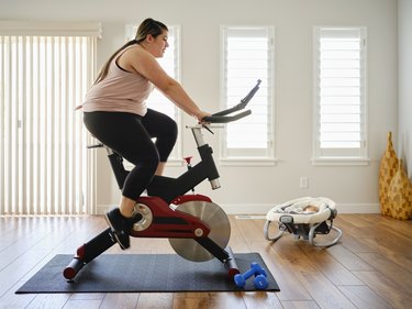 woman exercising on a stationary bike for cardio workout at home