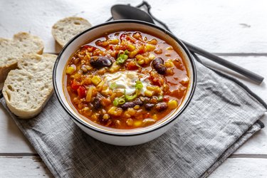 vegetarian healthy canned soup in a bowl with slices of bread next to it on a wooden table