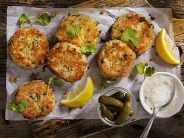 Crispy Golden crab Cakes on parchment paper with dipping sauce