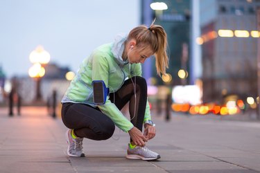 女人晚上在城市里跑步，以此来获得更多的深度睡眠