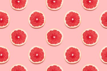 Grapefruit slices in a pattern on a pink background