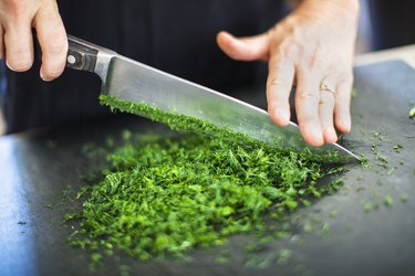 chopping parsley with a knife from a set of chef's knives