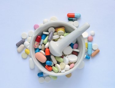 Heap of medicine pills and capsules on a white background.