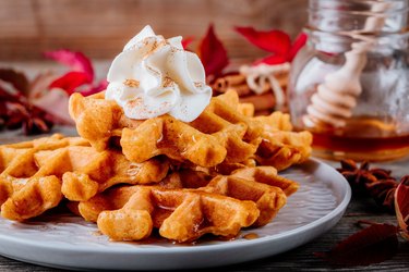 Pumpkin spice waffles with whipped cream for Thanksgiving Day.