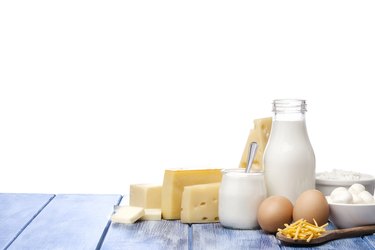 Assortment of dairy products, a food rich in sulfur,  shot on blue striped table against blue striped table