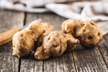 close up of raw jerusalem artichoke on wooden table as example of what to eat for ibs diarrhea