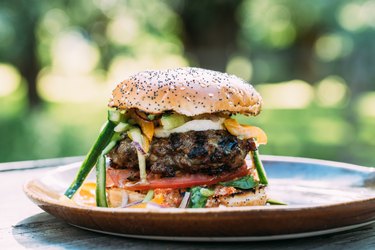 juicy homemade cheeseburger on wooden cutting board