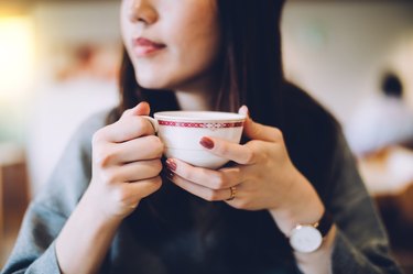 Smiling woman enjoying cup of coffee in a coffeeshop