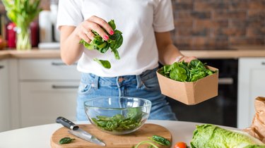 close view of a person making a spinach salad, as an example of foods high in magnesium