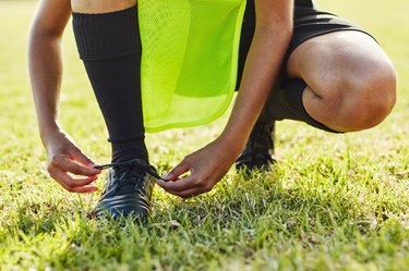 close view of a person's foot in soccer cleats, as an example of what causes a black toenail