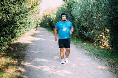 person with overweight doing beginner walking plan outside