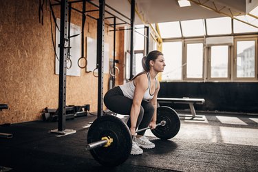 Strong woman training with weights in gym