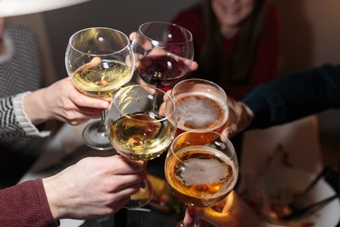 close up of people toasting with wine