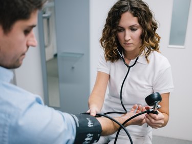 young female doctor measures blood pressure