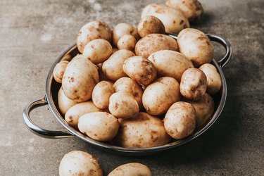Young farm potatoes. Raw potato on a table.