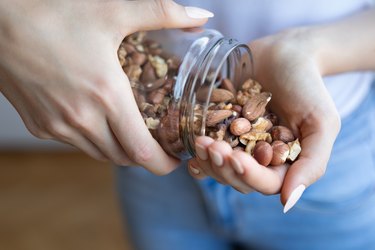person dishing out a handful of nuts