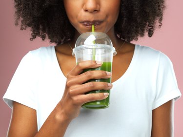 A woman drinking green juice