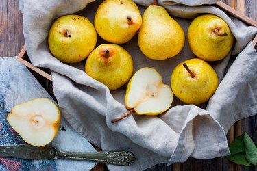 Chopped fresh yellow pear on a wooden board, top view, selective focus Fruit background.