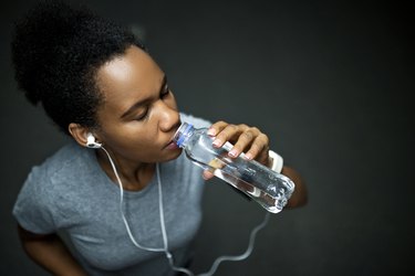 Woman with headphones drinking water