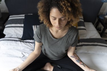 Woman meditating before bed, as a natural remedy for insomnia
