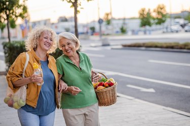 Portrait of two happy older adults carrying energizing foods