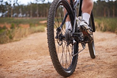 Close-up image of a person riding a 21-speed bike from behind.