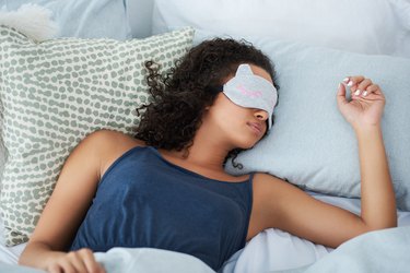 woman sleeping in bed and wearing an eye mask