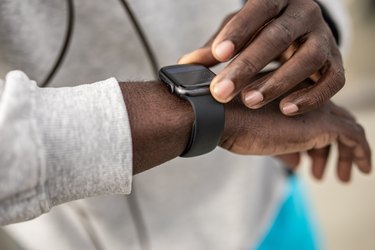 Person checking smartwatch for heart rate and calories burned.