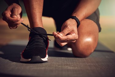 closeup shot of a man lacing new running shoes