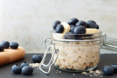 jar of overnight oats with blueberries and bananas with white and black background