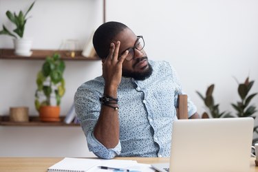 man sitting at his desk and feeling forgetful