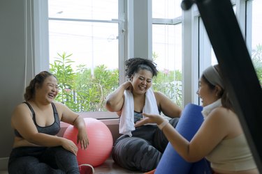 Group of gym-goers laughing after a workout together.