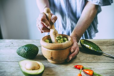 Close-up of hands making homemade guacamole