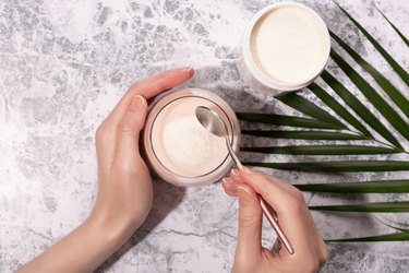 Woman hands, collagen powder and smoothie.