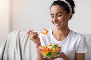 Closeup of beautiful young woman eating healthy salad
