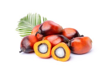 Pile of oil palm fruit, cut in half to show the flesh and kernel that are used to make saturated fat-rich palm oils.