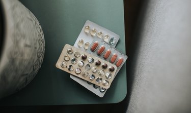 Close up of iron pills in a container on a green nightstand