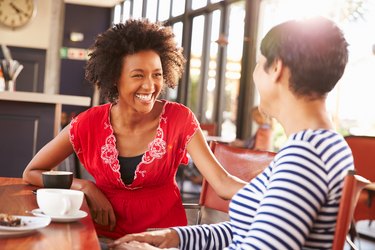 Two female friends talking at a coffee shop