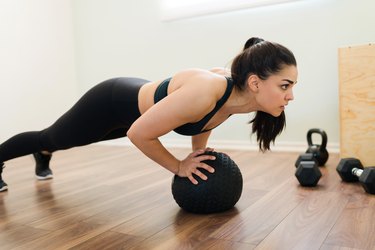 Athlete performing diamond push-ups on ball.