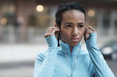 Mixed race runner listening to earbuds