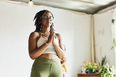 Medium wide shot low angle view of woman relaxing after finishing yoga class in studio