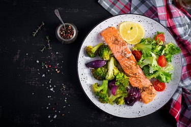 Baked salmon fillet with broccoli, red onion and lemon. Top view, overhead