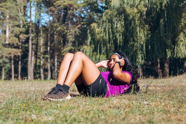 Adult performing crunches during outdoor workout.