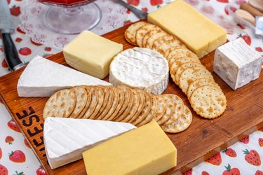 Wooden board with various cheeses and crackers for a low-res diet