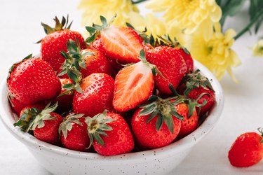 Fresh ripe juicy strawberries in a bowl on a white background