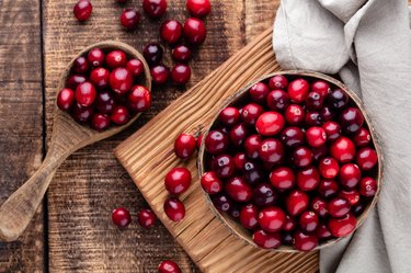Red cranberries on wooden background. Berries in a bowl.