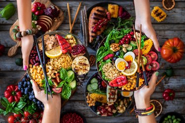 Hands of two women with buddha bowl at the restaurant