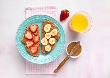 Plant based breakfast of whole grain toast, almond butter and fruit