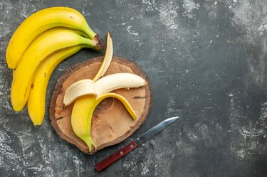 Above view nutrition source fresh bananas bundle and peeled